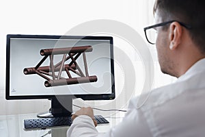 Engineer, Constructor, Designer, Architect in Glasses Working on a Personal Computer. He Creating New Component of beam