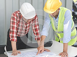 Engineer and consultants planning construction process and look on blueprint.