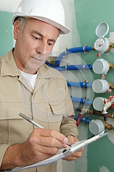 engineer controlling heating pipes at boiler room