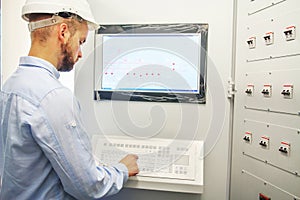 Engineer controls technological equipment from remote control board. Scada system for automation equipment photo