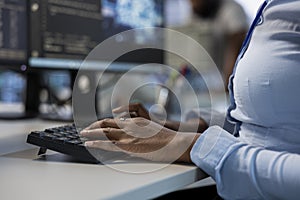 Engineer in data center typing on keyboard, optimizing IT infrastructure