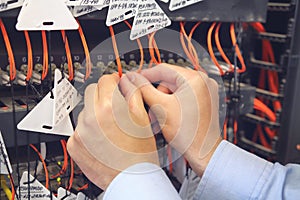 Engineer in data processing center of ISP Internet Service Provider hold fiber patch cords.