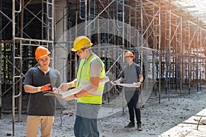 Engineer discussing with foreman about project in building construction site. Engineer and Architect working at Construction Site