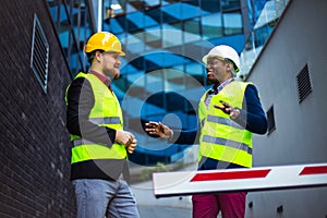 Engineer discussing the structure of the building with architects colleague at construction site