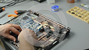 The engineer dismantles the laptop for repair