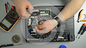 The engineer dismantles the laptop for repair