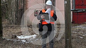 Engineer with documentation near powerline