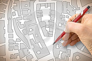 Engineer drawing an imaginary map of an historical center of an old town with buildings, roads and land parcel - construction