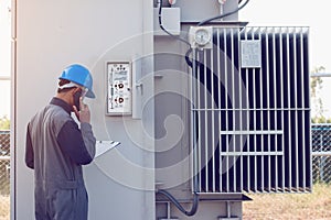 engineer or electrician working on checking and maintenance equipment at green energy solar power plant; checking status step up photo