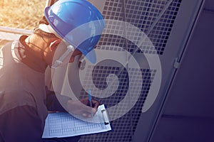 engineer or electrician working on checking and maintenance equipment at green energy solar power plant; checking status step up