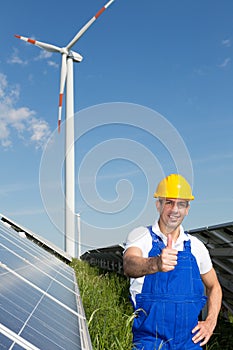 Engineer at energy park with solar panels and wind turbine