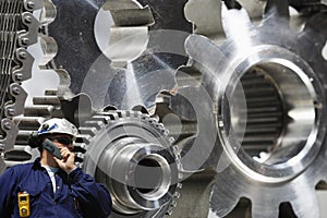 Engineer examining large gears and cog machinery