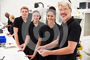 Engineer In Factory With Apprentices Checking Components