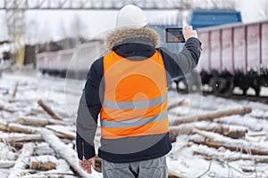 Engineer filmed on the tablet PC near the freight wagons