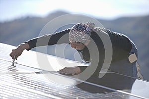 Engineer Fixing Solar Panel On Rooftop