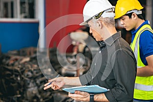 Engineer foreman manager working check stock with young male staff worker