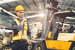 Engineer foreman using walkie talkie radio operate control loading cargo in warehouse portrait confident