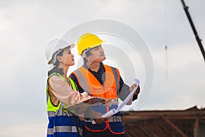 Engineer and foreman worker checking project at building construction site