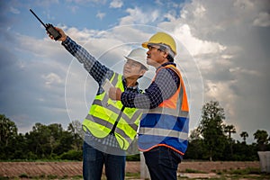 Engineer and foreman worker checking project at building site, Engineer and builders in hardhats discussing on construction site,