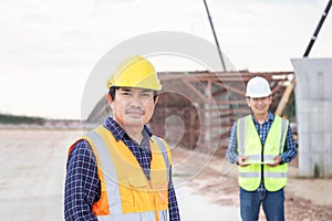 Engineer and foreman worker checking project at building site, Engineer and builders in hardhats in infrastructure construction