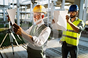 Engineer, foreman and worker discussing in building construction site