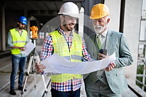 Engineer, foreman and worker discussing in building construction site