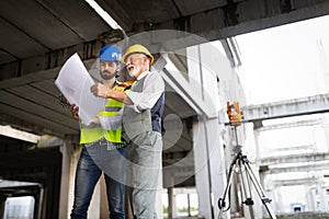 Engineer, foreman and worker discussing in building construction site