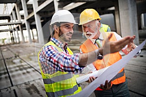 Engineer, foreman and worker discussing in building construction site