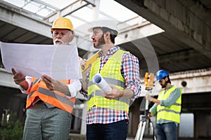 Engineer, foreman and worker discussing in building construction site