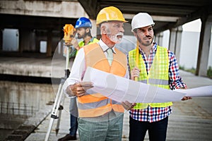 Engineer, foreman and worker discussing in building construction site