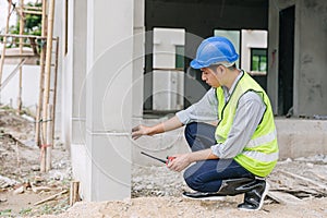 Engineer foreman working checking detail of home building pillars build quality at construction site