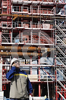Engineer in front of factory constructions