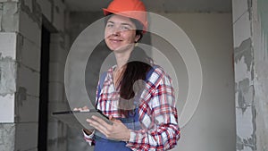 engineer with gadget in building under construction. Modern construction woman engineer or architect at construction