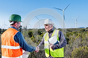 Engineer and geologist consult close to wind turbines in the countryside