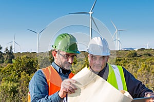 Engineer and geologist consult close to wind turbines in the countryside