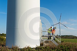 Engineer and geologist consult close to wind turbines in the countryside