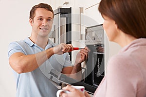 Engineer Giving Advice To Woman On Kitchen Repair