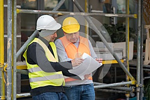 Engineer giving colleague arrangements about a new construction site. Outdoors