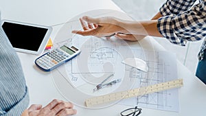 Engineer Hand Drawing Plan On Blue Print with architect equipment discussing the floor plans over blueprint architectural plans at