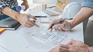 Engineer Hand Drawing Plan On Blue Print with architect equipment discussing the floor plans over blueprint architectural plans at