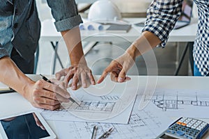 Engineer Hand Drawing Plan On Blue Print with architect equipment discussing the floor plans over blueprint architectural plans at