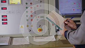 Engineer hands writing information from industrial electronic control board, control panel.