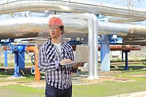 Engineer in hardhat with laptop