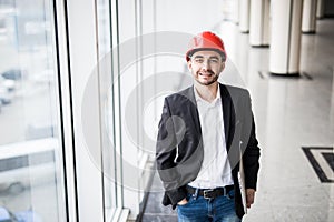 Engineer in hardhat with laptop computer, smiling at camera.