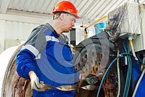 Engineer in helmet inspects and repairs gas equipment of boiler room. Cleaning and maintenance of gas boiler.