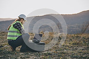 The engineer in the helmet works at the factory with an laptop. Creation of new technologies, production development