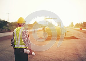 Engineer holding blueprint in construction site