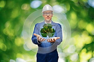 Engineer holding a green planet Earth with recycling symbol