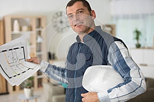 engineer holding plan while smiling at camera