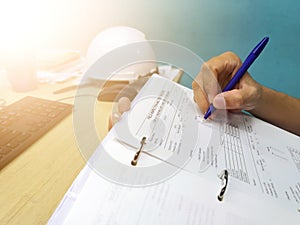 Engineer inspecting and checking datasheet.